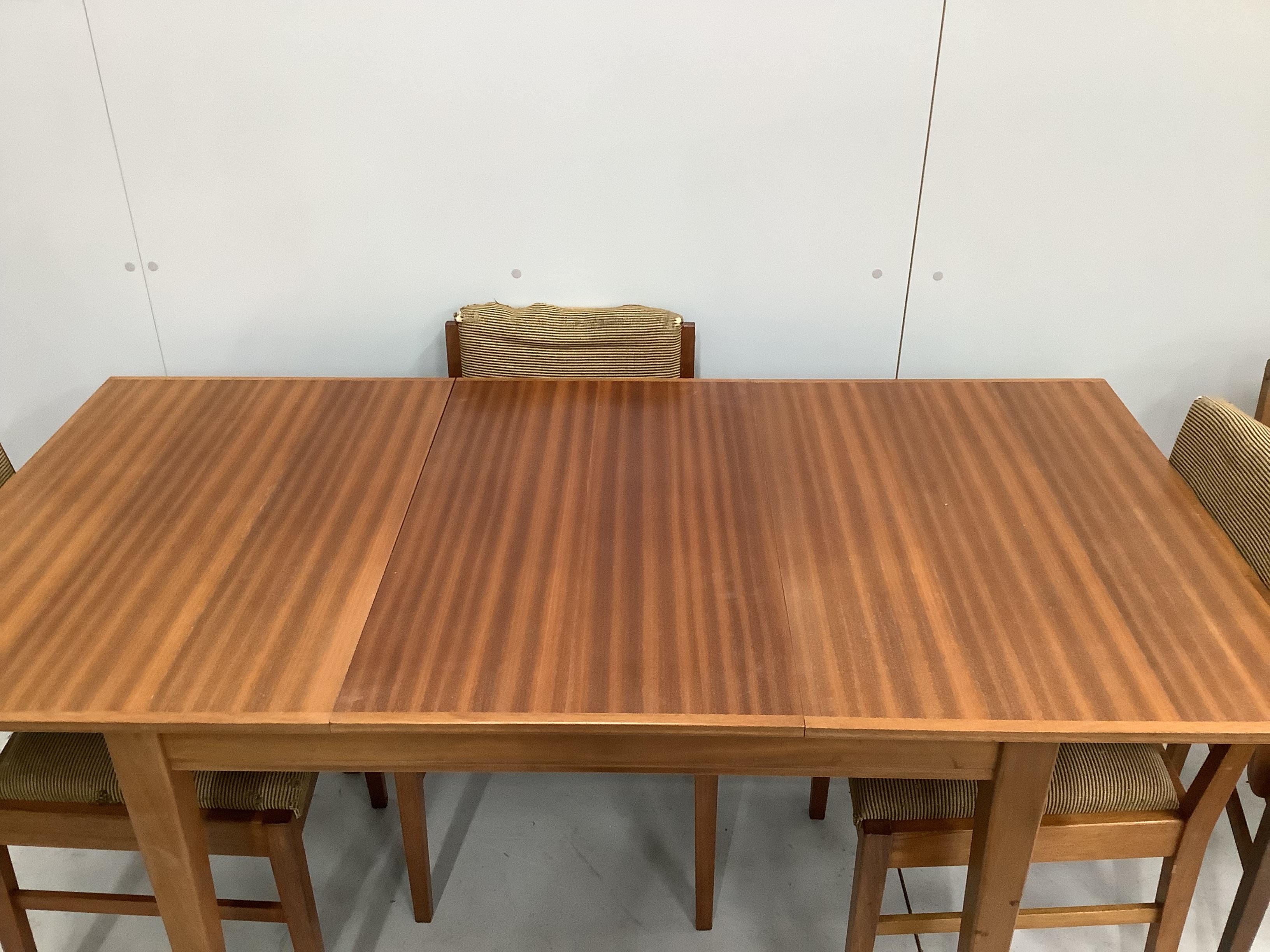 A Gordon Russell Broadway, mid century teak extending dining table, 153cm extended, width 78cm, height 77cm and five chairs, one with arms.